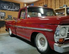 an old red truck parked in a garage