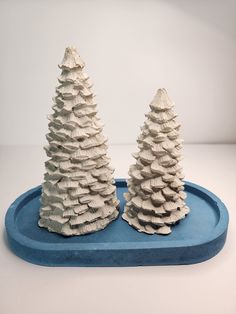 two small white trees on a blue tray