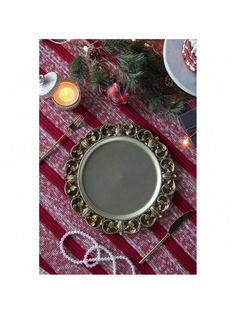 a silver plate sitting on top of a red and white table cloth next to a christmas tree