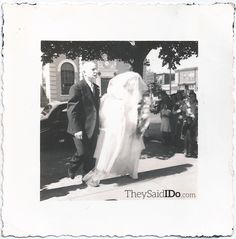 an old black and white photo of a bride and groom walking down the street together