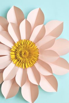 a paper flower on a blue background with the center cut out to look like petals