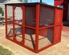 a red chicken coop sitting in the middle of a yard