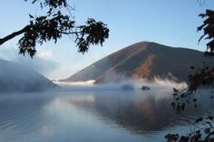 a boat floating on top of a lake surrounded by mountains