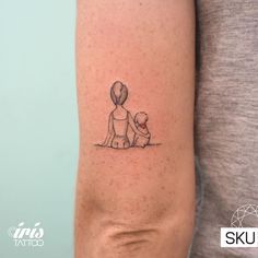 a woman's arm with a small tattoo of a boy and dog on it