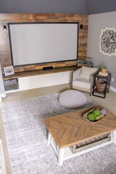 a living room with a large screen on the wall