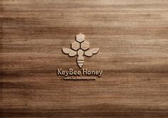 the logo for keybee honey is shown on a wooden surface with a pencil in it