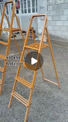 two wooden ladders sitting next to each other on top of a cement ground in front of a building