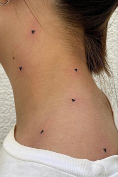 the back of a woman's neck with small black birds on her left side