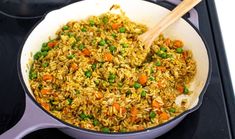 a pan filled with rice and peas on top of a stove