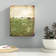 a painting on the wall next to a bowl with plants in it