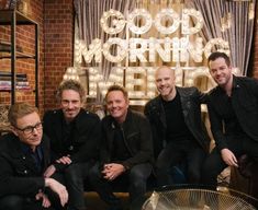 three men sitting next to each other in front of a sign that says good morning america