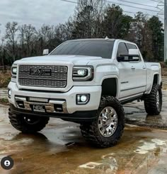 a white truck is parked in the mud