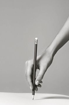 a person holding a pencil in their hand