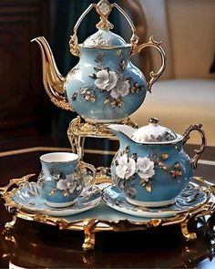 a blue tea set with white flowers on it