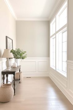 an empty room with white walls and wood flooring is pictured in this image, there are two vases on either side of the wall