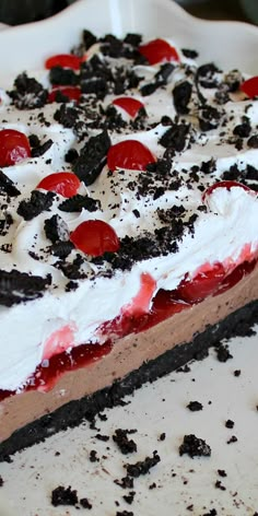 a large piece of cake on a plate with oreo crust and red cherries