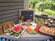 a table topped with sandwiches and cupcakes