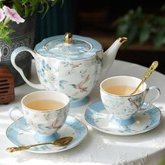 two tea cups and saucers on a table