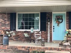 a front porch with chairs and a blue door