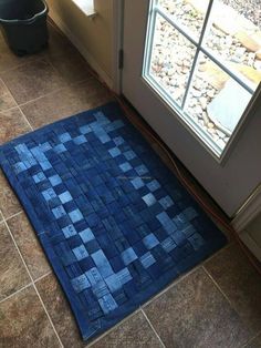 a blue area rug sitting on the floor next to a door with an open window