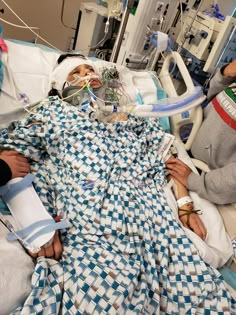 a woman laying in a hospital bed with an oxygen tube hooked up to her head