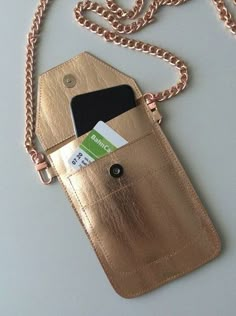 a cell phone in a gold leather case with a credit card holder attached to it