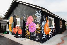 a black building with colorful flowers painted on it