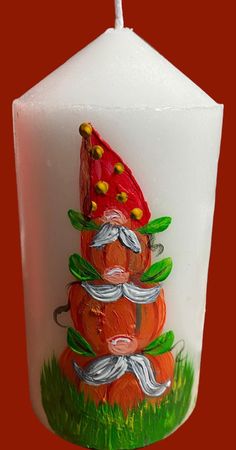 a white candle with a red hat and mustaches on it