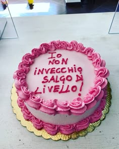 a birthday cake with pink frosting and writing on the top that says, to no invecchine salgon i velo