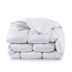 a pile of white down comforters stacked on top of each other in front of a white background