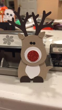 an image of a reindeer made out of paper on a table with other items in the background