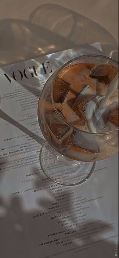 a drink in a wine glass on top of a table next to a paper with the word yogurt written on it