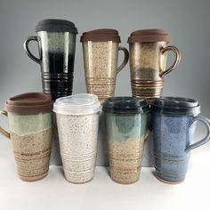 there are many coffee cups lined up together