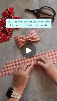 someone is making a bow tie out of fabric and scissors on the table next to it