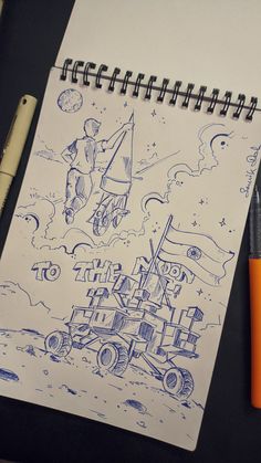 a notebook with a drawing of a man on the moon and an orange pen next to it