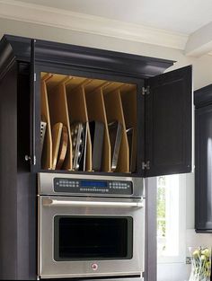 the kitchen cabinets are open with knives and pans in them on top of each other