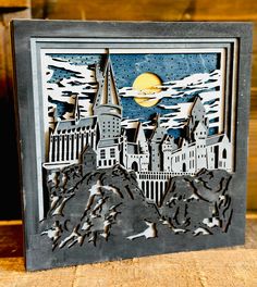 a paper cut out of hogwarts castle in front of a full moon