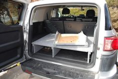 the back end of a white van with an open trunk and trays in it