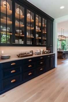 a kitchen with dark blue cabinets and wooden floors is pictured in this image from the front view