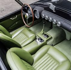 the interior of an old car with green leather seats