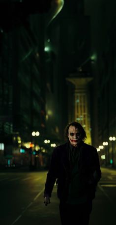 the joker is walking down the street at night