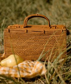 This gorgeous picnic basket is handwoven with rattan and features exquisite signature bowtie closure on each side. Details: -Size: 6" H x 12" L x 9" W -Material: Rattan/ata -Made in Indonesia Indian Picnic, Bedside Carafe, Wood Gallery Frames, Carafe Set, Adornment Jewelry, Harvest Basket, Village Green, Rose Window, Outdoor Textiles