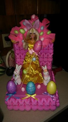 a barbie doll sitting on top of a pink chair surrounded by easter eggs and decorations