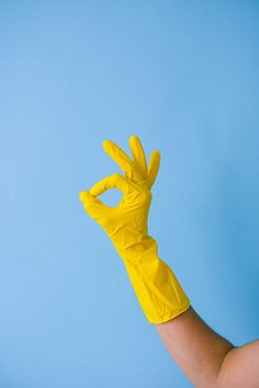 a person wearing yellow gloves is holding up their hand