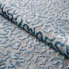 a close up view of a blue and grey fabric with an intricate design on it