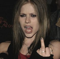 a woman with long hair pointing at the camera