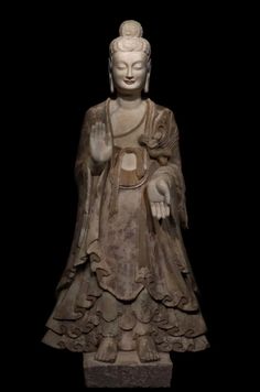 a buddha statue sitting on top of a black background