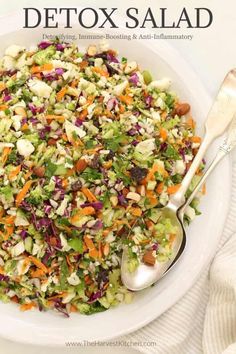 a white plate topped with a salad and two spoons