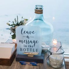 a bottle with leave a message in it sitting on a table next to some candles