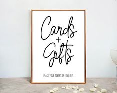 a poster with the words cards and gifts on it next to a glass of wine